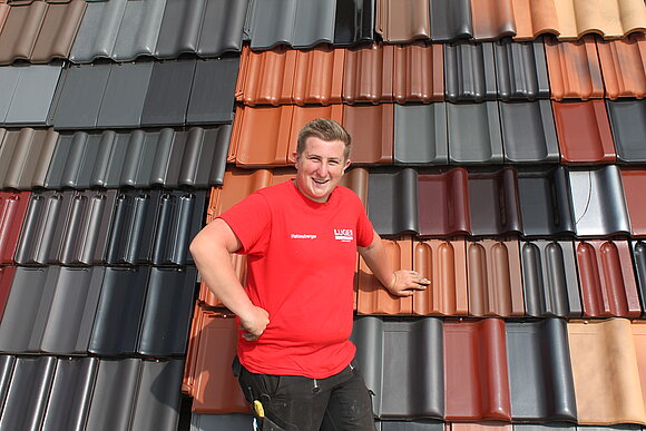 Mann in rotem T-shirt vor verschiedenen Dachziegeln
